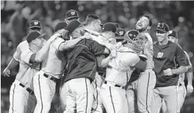  ?? MIKE ZARRILLI/GETTY PHOTO ?? The Washington Nationals celebrate Tuesday night at Turner Field after clinching their second National League East title in three years against the Atlanta Braves.