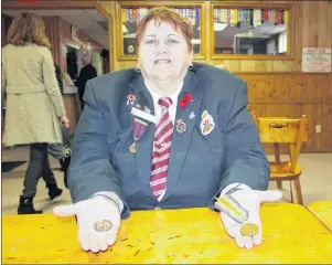  ?? NIKKI SULLIVAN/CAPE BRETON POST ?? Ann Mischiek, a member of the ladies auxiliary of the Royal Canadian Legion branch 12 in Sydney, holds two medals from the First World War in her hands while sitting at the legion on Sunday. The medal on the left is the King George medal, which was in the pouch with her great-uncle John Alex Shaw’s medals. It belonged to P. Campbell and Mischiek is hoping to track down Campbell’s family members to give it to them. The medal on the right is the Victory Medal, which was awarded to her great-uncle.