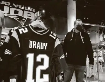  ?? Elise Amendola / Associated Press ?? Brian Pope browses for Tom Brady jerseys in the pro shop at Gillette Stadium.