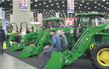  ?? — Reuters ?? People look at Deere equipment as they attend National Farm Machinery show in Louisville, Kentucky.