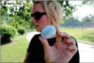  ?? JONATHAN TRESSLER — THE NEWS-HERALD ?? Holly Heron holds up a rock she and her three children found June 14 while hiding some painted rocks of their own in conjunctio­n with the Northeast Ohio Rocks! Facebook group. Its members paint and hide rocks for others to find and, in turn, hide again...