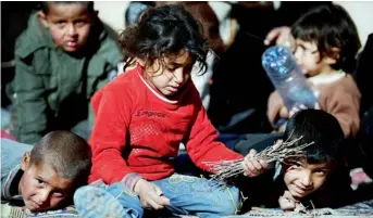  ?? AFP ?? INNOCENCE LOST… Syrian children collect wood to light a fire at the border town of Akcakale in Sanliurfa. —