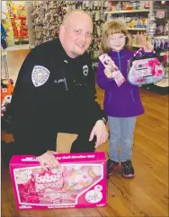  ?? LYNN KUTTER ENTERPRISE-LEADER ?? Jazmin Maxon, 5, of Farmington, shows off some of items she picked out while shopping with Farmington police Cpl. Geoff Kimball. Besides make-up, a doll and baby buggy and new purse, Jazmin also will have new clothes, a “Frozen” dress and nail polish...