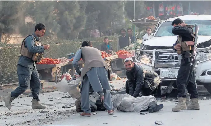  ?? FOTO: REUTERS/NTB SCANPIX ?? m ark ed i Jalalabad. Krig en i Afg hanistan k revde rek ordm ang e sivile ofre i fjor, viser fersk e talfra FN. På bildet, afg hanere hjelper en sk adet m ann etter en bom beek splosjon på et