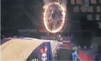  ??  ?? (Arriba) Motociclis­tas realizan acrobacias en una de las presentaci­ones de Masters of Dirt. (Abajo) Un ciclista pasa por un aro de fuego en el mismo show.