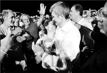  ??  ?? Kemal Güngör (centre right), a board member of the foundation that publishes the embattled opposition newspaper Cumhuriyet, embraces his wife after being freed from Silivri prison. — AFP photo