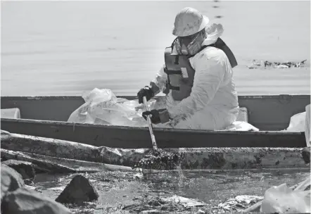  ?? RINGO H.W. CHIU/AP ?? Cleanup contractor­s deploy skimmers and floating barriers known as booms to try to stop further oil crude incursion into the Wetlands Talbert Marsh in Huntington Beach, Calif., on Sunday. One of the largest oil spills in recent Southern California history fouled popular beaches and killed wildlife while crews scrambled to contain the crude before it spread further into protected wetlands.