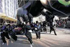  ?? Hiroko Masuike / New York Times file ?? Winds like these pushing handlers around at the 2013 Macy’s Thanksgivi­ng Day Parade may force grounding of floats. A decision will be made on parade day.