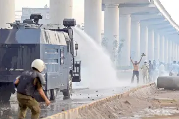  ?? ARIF ALI/AGENCE FRANCE-PRESSE ?? POLICE use water cannon to disperse supporters of Tehreek-e-Labbaik Pakistan during a protest in Lahore.