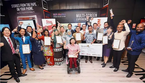  ??  ?? One for the album: Fu (centre, in white) flanked by Lee (on Fu’s right) and Wong along with Sharifah (centre in blue tudung) posing in a group photo with the judges and winners of the Star Golden Hearts Award 2018 at Menara Star in Petaling Jaya.