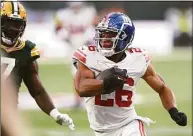  ?? Stu Forster / Getty Images ?? The Giants’ Saquon Barkley rushes for a big gain against the Green Bay Packers on Oct. 9 at Tottenham Hotspur Stadium in London.