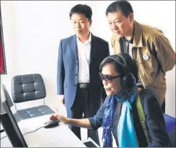  ??  ?? A woman uses a system designed to assess the accuracy of spoken Putonghua.