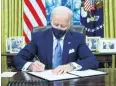  ?? PHOTO: REUTERS ?? New US President Joe Biden signs executive orders in the Oval Office of the White House after his inaugurati­on yesterday.