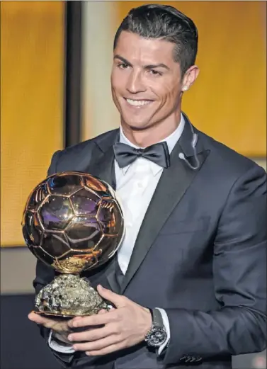  ??  ?? ORO, EN LAS BOTAS Y EN LAS MANOS. Cristiano, con el Balón de Oro 2014, el último que logró.