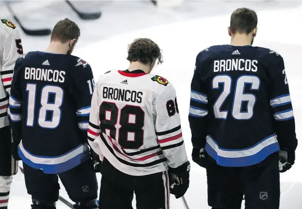  ?? JASON HALSTEAD / GETTY IMAGES ?? Winnipeg Jets forwards Bryan Little, left, and Blake Wheeler flank Chicago Blackhawks right wing Patrick Kane while wearing jerseys honouring the Humboldt Broncos before Saturday’s game in Winnipeg. A crash involving the Broncos’ bus killed 15 people...