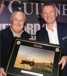  ??  ?? Photograph­er Ger Hore receives a presentati­on from Brian Cantwell of Diageo in recognitio­n of Ger’s coverage of the Singing and Swinging Pubs competitio­n for the Wexford People.