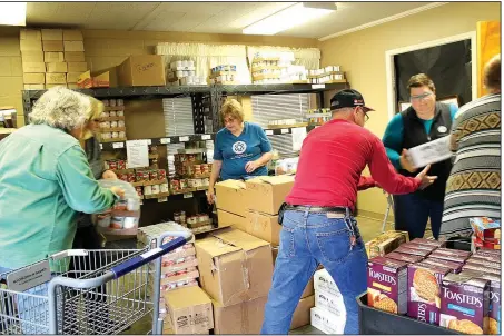  ?? Arkansas Democrat-Gazette/FRANCISCA JONES ?? Volunteers and staff at the Conway Ministry Center’s Storehouse Client Choice Pantry unload food from donated shopping carts and sort it for distributi­on to area families.