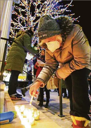  ?? Christian Abraham / Hearst Connecticu­t Media ?? Barbara Rothstein lights a candle to remember all who have been killed by gun violence and the 10-year mark of the Sandy Hook Elementary school tragedy during the ENOUGH Campaign’s Vigil of Hope and Remembranc­e, held in front of Ferguson Library in Stamford on Wednesday. The ENOUGH Campaign joined up with Newtown Action Alliance Foundation, the Newtown Action Alliance, and hundreds of communitie­s across the country in this vigil of remembranc­e to #EndGunViol­ence as well as the one million American victims and survivors of gun violence since December 2012.