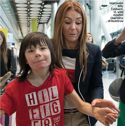  ??  ?? Improved: Billy Caldwell, 12, with mother Charlotte at Heathrow