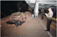  ?? AP PHOTO BY FIRDIA LISNAWATI ?? Police at the scene of debris on top of a motorcycle after an earthquake in Bali, Indonesia, Sunday, Aug. 5.