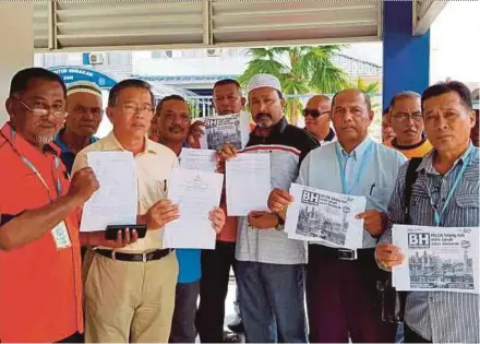  ?? PIC BY ABNOR HAMIZAM ABD MANAP ?? Felda Raja Alias Tiga settlers showing the report that they lodged at the Bandar Seri Jempol police station in Negri Sembilan yesterday.