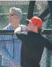  ?? KENNETH K. LAM/STAFF ?? Orioles infielder Jackson Holliday takes swings in the batting cage as executive vice president and general manager Mike Elias looks on during spring training in Sarasota, Florida.