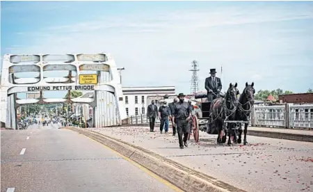  ?? TIMOTHY IVY/THE NEW YORK TIMES ?? A horse-drawn wagon carries the casket of Rep. John Lewis on Sunday across the Edmund Pettus Bridge in Selma.