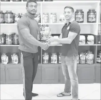  ??  ?? Recently, CEO of Guyana’s leading supplement and gym equipment supplier, Jamie McDonald made a timely presentati­ons to powerlifte­r, Carlos Petterson to help boost his chances of medaling at the 16th Caribbean/NAPF Championsh­ips scheduled for August 2-4...