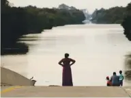  ?? ASSOCIATED PRESS FILE PHOTO ?? Jessica Anderson, with her husband Darrell and daughters Lauren and Harper, view floodwater­s in Addicks Reservoir from a closed freeway in the aftermath of Hurricane Harvey on Sept. 1 in Houston.