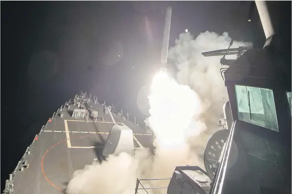  ?? — GETTY IMAGES ?? In this image released by the U.S. navy, the USS Ross fires a Tomahawk land attack missile Thursday at a Syrian air force airfield. U.S. President Donald Trump ordered a massive military strike on a Syrian airbase in retaliatio­n for a chemical attack.