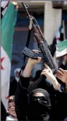  ?? AP ?? A woman hoists an AK-47 during an anti-government rally Friday on the outskirts of Idlib, Syria.