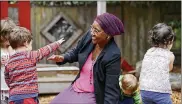  ?? ELAINE THOMPSON / AP ?? Teacher Fatuma Yusuf interacts with children on the playground at the Wallingfor­d Child Care Center in Seattle amid a dire workforce crisis.