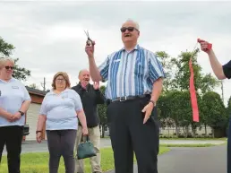  ?? SHELLEY JONES/POST-TRIBUNE ?? Billy Coker, president of the Portage Township Advisory Board, and liaison between the board and the Eunice Bonner Senior Center, cuts the ribbon Wednesday to open a new mile fitness trail.