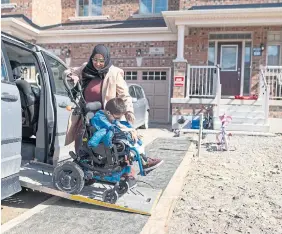  ?? PETER POWER FOR THE TORONTO STAR ?? Khadija Zafar helps her son out of the van at the family's home in Waterdown. The family has yet to find a wheelchair-accessible home they can afford.