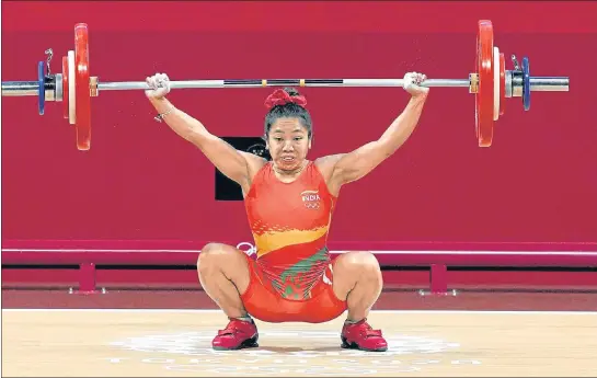  ??  ?? India's Mirabai Chanu in action during the women’s 49kg weightlift­ing event at the Tokyo Olympic Games in Tokyo on Saturday.