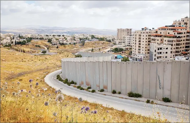  ??  ?? In this June 19, 2020 photo, a view of Shuafat refugee camp is seen behind section of Israel’s separation barrier in Jerusalem on June 19. (AP)