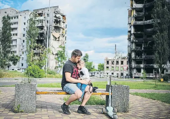  ?? ?? En Maksim abraça la seva filla Nazia en un banc de Borodianka, una de les ciutats als afores de Kíiv arrasades per les tropes russes