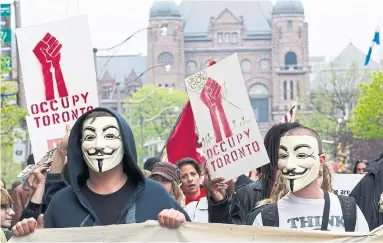  ?? NATHAN DENETTE THE CANADIAN PRESS FILE PHOTO ?? Occupy Toronto protesters march through the streets of downtown Toronto on May Day in 2012.