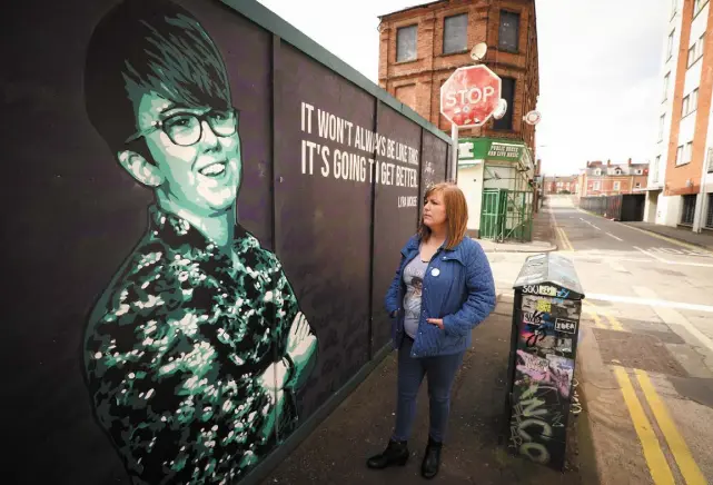  ?? Picture by Kelvin Boyes/Press Eye ?? ● Nichola Corner-McKee stands beside a mural depicting her sister Lyra in Belfast. ‘The night Lyra was killed, my soul jumped out of my body and never returned,’ she says. Detective Supertinte­ndent Jason Murphy says a ‘web of fear’ now hangs over Derry’s Creggan.