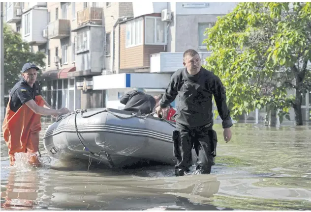  ?? AFP ?? Ukrainian security forces transport a local resident in a boat during an evacuation from a flooded area in Kherson yesterday.