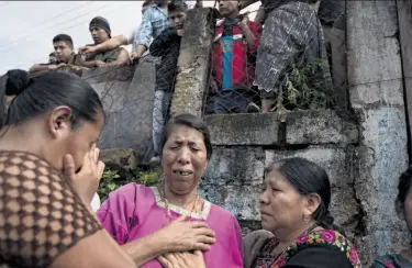  ?? Moises Castillo / Associated Press ?? Relatives mourn victims slain in the mountain town of San Jose Nacahuil, near Guatemala City.