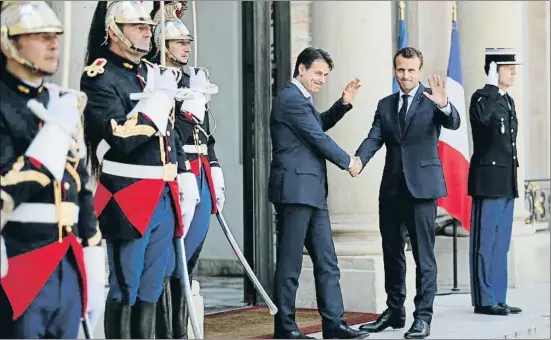  ?? FRANCOIS MORI / AP ?? Giuseppe Conte y Emmanuel Macron saludan desde lo alto de la escalinata del palacio del Elíseo, ayer en París