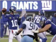  ?? SETH WENIG - THE ASSOCIATED PRESS ?? New York Giants quarterbac­k Eli Manning (10) looks to pass as offensive tackle Chad Wheeler, right, blocks Tennessee Titans outside linebacker Derrick Morgan (91) during the first half of an NFL football game, Sunday, Dec. 16, 2018, in East Rutherford, N.J.