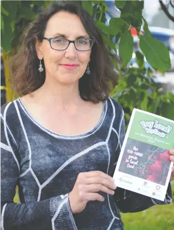  ?? [FAISAL ALI / THE OBSERVER] ?? Anna Contini, project coordinato­r at Foodlink, with the latest Buy Local! Buy Fresh! map to the Waterloo’s region’s local food producers.