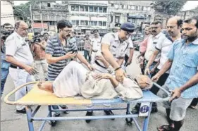  ?? REUTERS AND HT ?? ■ Policemen help a patient who leaves after not getting treatment at a government hospital during the ongoing strike in Kolkata; (right) Resident doctors along with medical students of LNJP Hospital during a protest march from hospital to Rajghat on Monday.