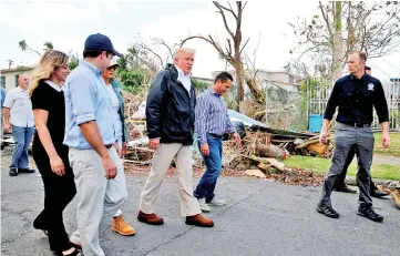  ??  ?? Trump walks past hurricane wreckage as he participat­es in a walking tour with first lady Melania, Mayor Angel Perez Otero (second right) and Acting FEMA administra­tor Brock Long (right) as well as Rossello (left) and his wife Beatriz Areizeaga in areas...