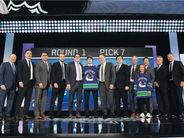  ?? GETTY IMAGES ?? Quinn Hughes dons his Canucks jersey and poses for obligatory photos after being selected seventh overall by the Vancouver Canucks at the NHL draft on Friday night. Canucks GM Jim Benning admits he’s coveted Hughes for two years and admires the young...