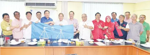  ??  ?? SAPAWI menyerahka­n bendera BN kepada Ketua Umno Beaufort Datuk Isnin Aliasnih pada majlis itu.