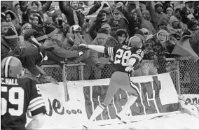  ?? ASSOCIATED PRESS FILE ?? Browns cornerback Ron Bolton hands off the ball to fans after intercepti­ng a pass from Raiders quarterbac­k Jim Plunkett and taking it in for a touchdown Jan. 4, 1981, at Cleveland Municipal Stadium.