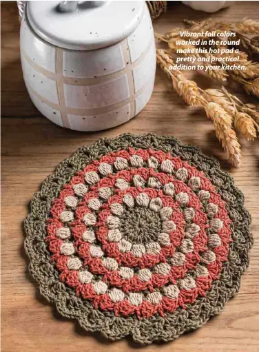  ??  ?? Vibrant fall colors worked in the round make this hot pad a pretty and practical addition to your kitchen.